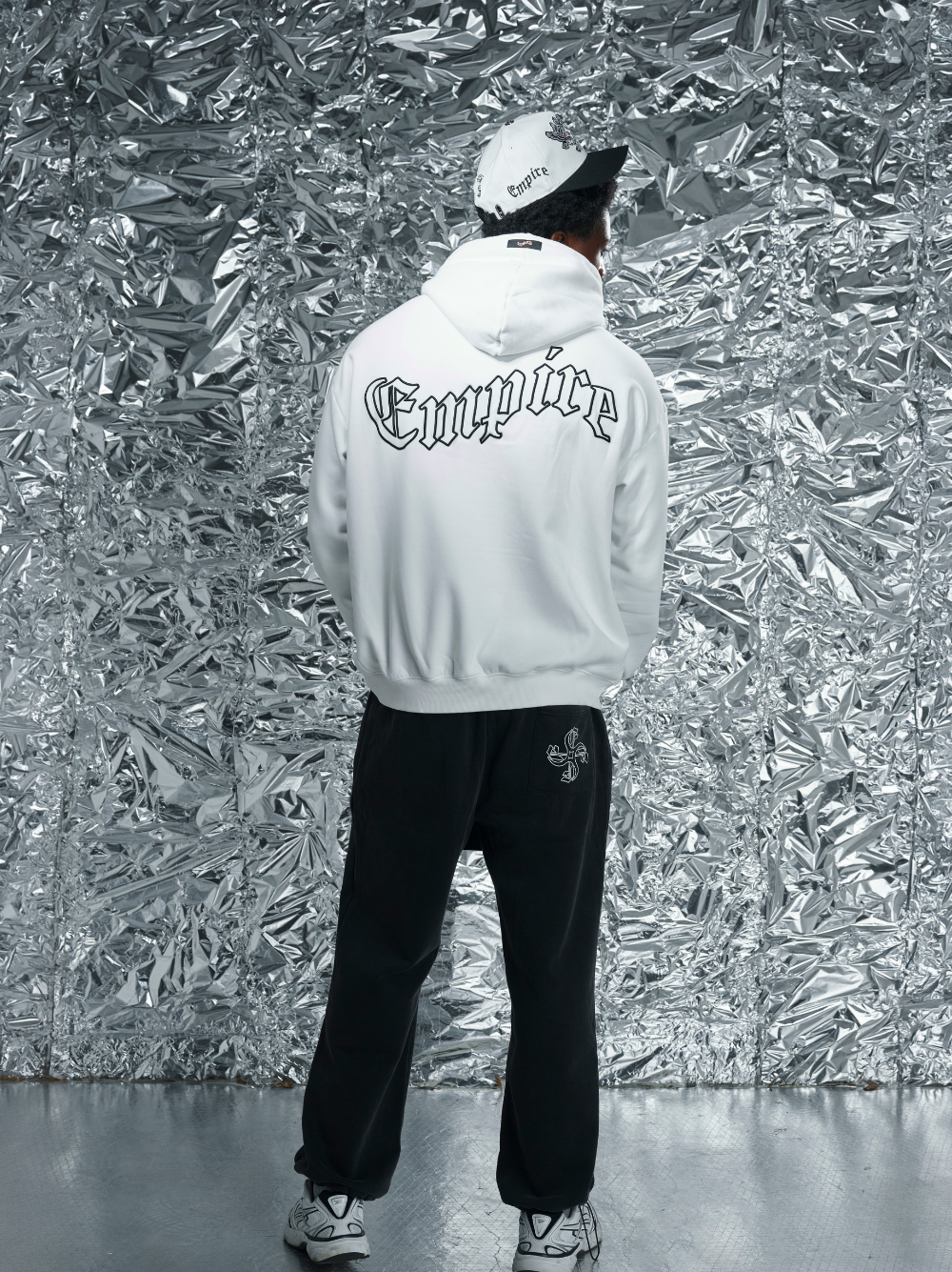 Empire white oversized graphic hoodie at unseen grail. local brands south africa. streetwear. men and women. studio image close up front male model standing