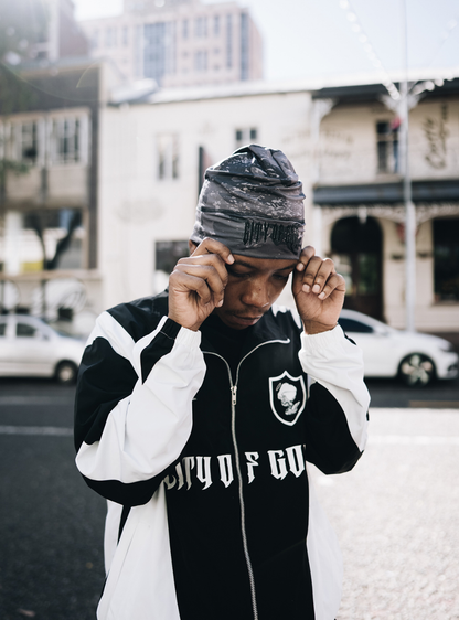 City of Gods black skull caps. local brands from south africa found at Unseen Grail. men and women. close up front male model holding beanie
