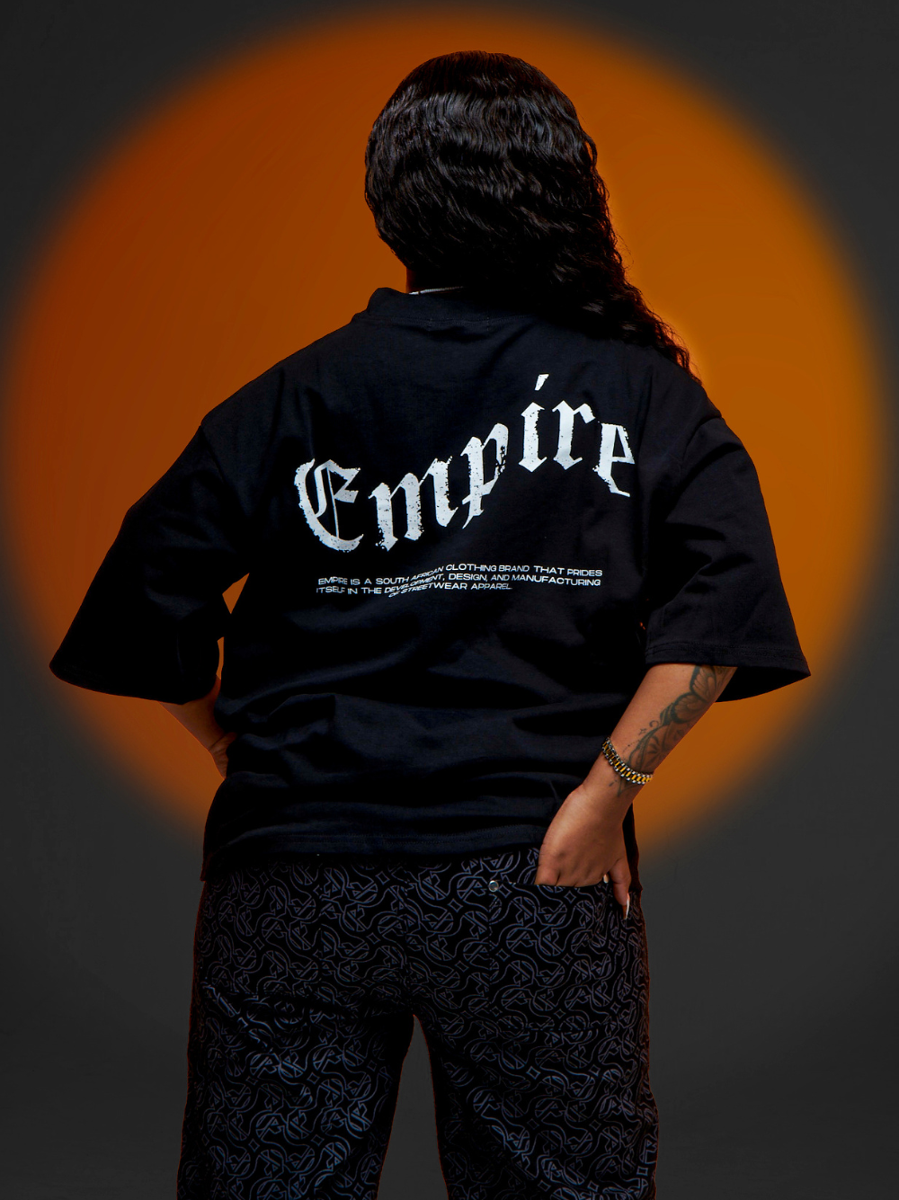 Empire black oversized graphic t shirt at unseen grail. local brands south africa. streetwear. men and women. studio image male model back view