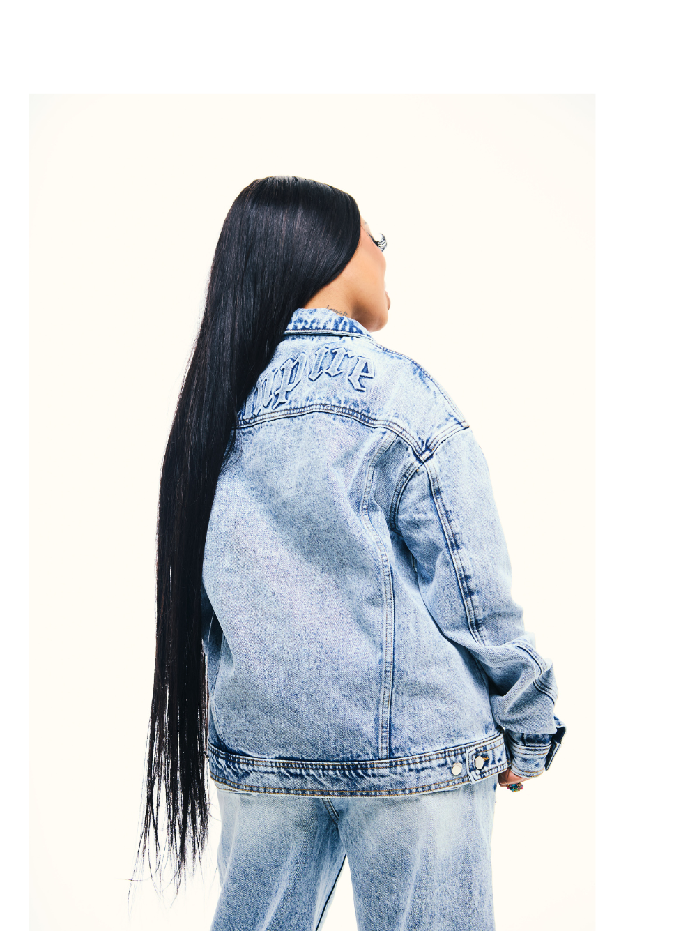 Empire blue denim jacket at unseen grail. local brands south africa. streetwear. men and women. studio image female model back view