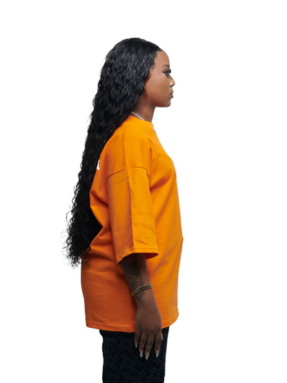 Empire orange oversized graphic t shirt at unseen grail. local brands south africa. streetwear. men and women. studio image female model close up side view