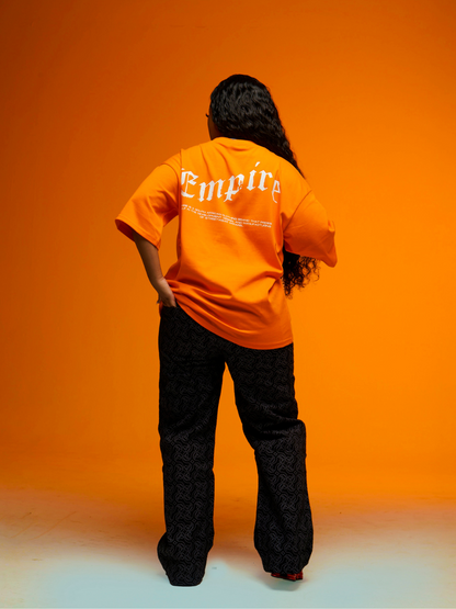 Empire orange oversized graphic t shirt at unseen grail. local brands south africa. streetwear. men and women. studio image female model full outfit back view