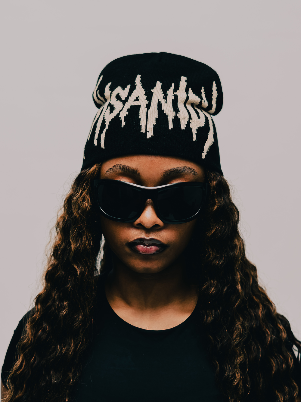 Insanidy knitwear black beanie at unseen grail. local brands south africa. streetwear. men and women. studio image female model front