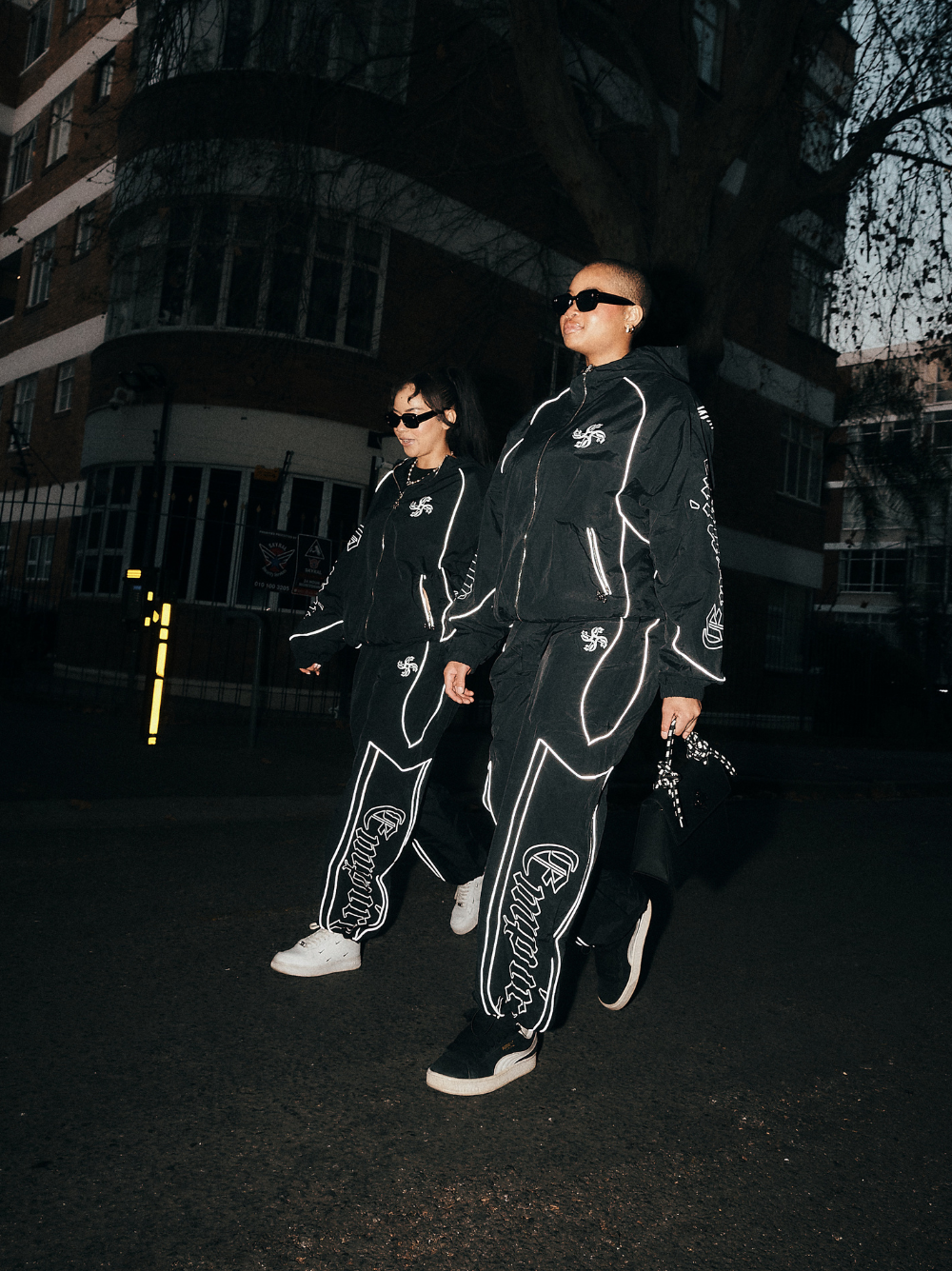 empire black oversized graphic tracksuit at unseen grail. local brands south africa. streetwear. men and women. group image galxboy, bantu full set women walking